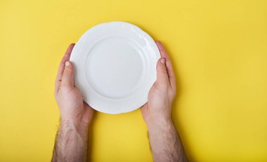 Boş seramik yuvarlak tabak holding erkek eller closeup 