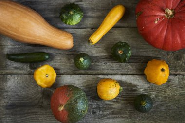 Dekoratif Güz pumpkins ve ahşap arka plan üzerinde taze squashes görüntüsünü