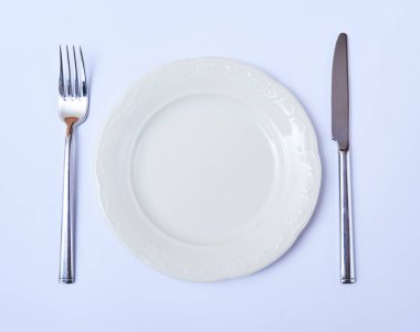Üstten Görünüm boş yuvarlak plaka çatal ve bıçak. Restoran tablo randevular