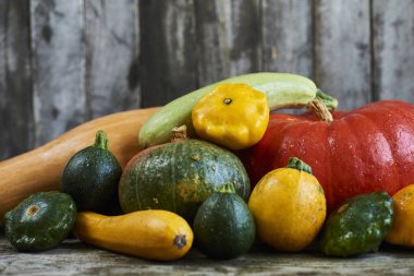 Dekoratif Güz pumpkins ve ahşap arka plan üzerinde taze squashes görüntüsünü