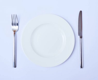 Üstten Görünüm boş yuvarlak plaka çatal ve bıçak. Restoran tablo randevular