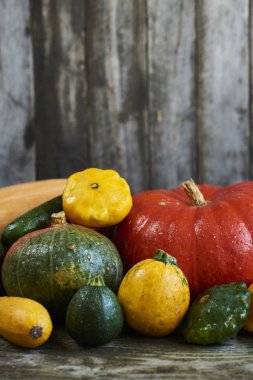 Dekoratif Güz pumpkins ve ahşap arka plan üzerinde taze squashes görüntüsünü