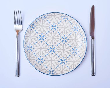 Üstten Görünüm boş yuvarlak plaka çatal ve bıçak. Restoran tablo randevular