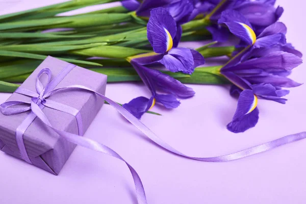 Вітальна Листівка Весняно Фіолетовими Квітами Крихітною Подарунковою Коробкою Фіолетовому Фоні — стокове фото