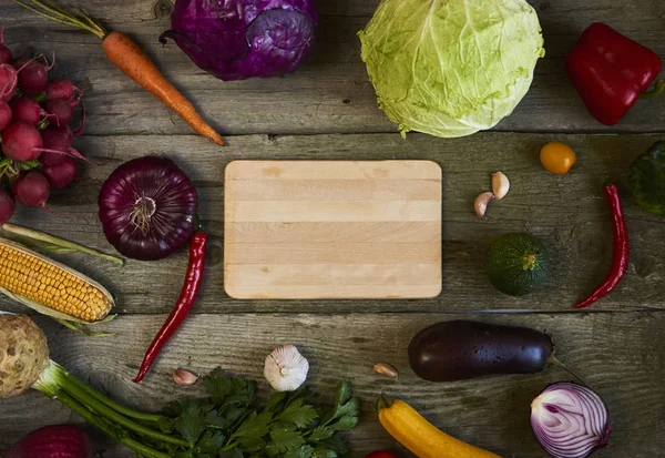 Surtido Frutas Verduras Frescas Con Tabla Cortar Sobre Fondo Madera — Foto de Stock