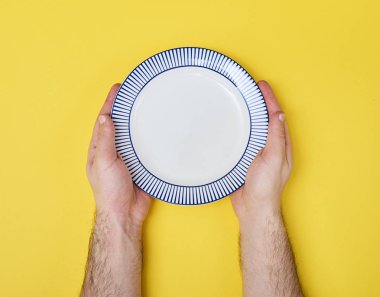 Boş seramik yuvarlak tabak holding erkek eller closeup 