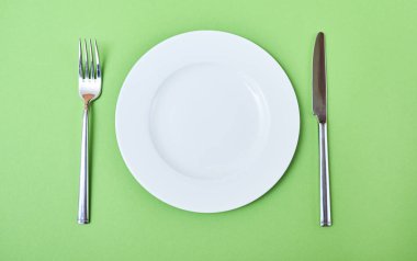 Üstten Görünüm boş yuvarlak plaka çatal ve bıçak. Restoran tablo randevular