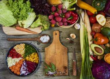 Ahşap arka plan üzerinde kesme tahtası ile taze çiğ sebze