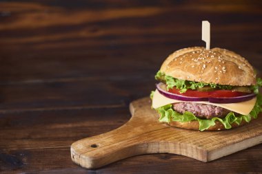 Kesme tahtası ahşap arka plan üzerinde taze lezzetli burger