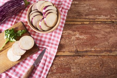 Mutfak havlusu ahşap rustik arka plan üzerinde üzerinde kesme tahtası üzerinde taze sağlıklı doğranmış patlıcan. Metin için yer