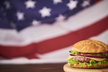 Amerikan bayrağı arka üzerinde kesme tahtası üzerinde taze lezzetli burger