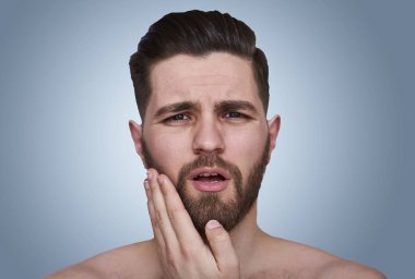 Mavi arka plan yüzünde dokunmadan yakışıklı adam portresi