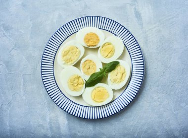 Lezzetli haşlanmış yumurta ile taze fesleğen yaprakları ahşap kase koyu kahverengi ahşap rustik zemin üzerinde 