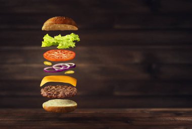 Metin için yer ile ahşap arka plan üzerinde kayan lezzetli Burger