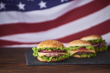 Taze lezzetli hamburger kesme tarihinde Amerikan bayrağı arka plan üzerinde kurulu