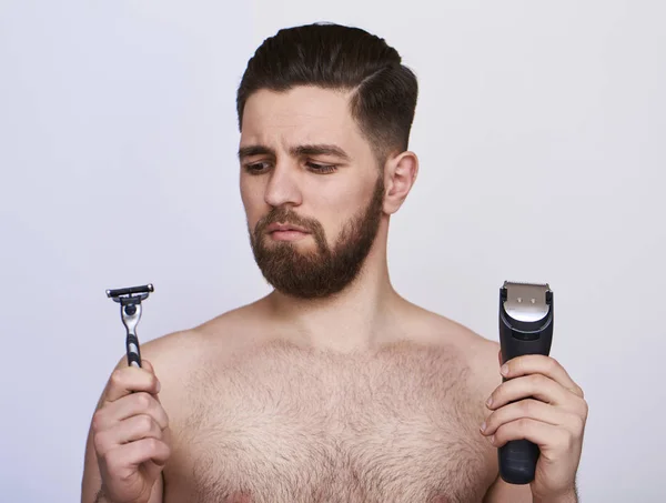 Hombre Joven Guapo Elegir Maquinilla Afeitar Recortar Sobre Fondo Gris — Foto de Stock