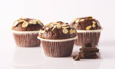 Üç lezzetli çikolata muffins beyaz arka plan üzerinde izole