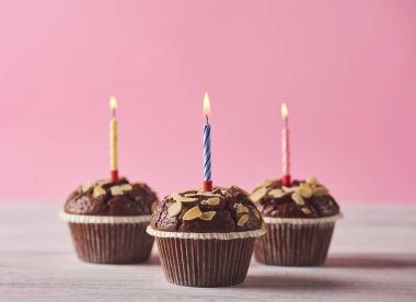 Doğum günü mumları üzerinde pembe bir arka plan ile lezzetli çikolatalı kek. En az kavramı
