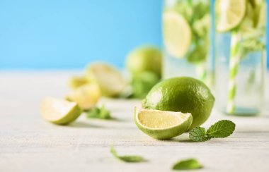 Yakın çekim görünümü taze limes ve nane. Mojito kokteyller, ufuk arka plan cam şişelerde