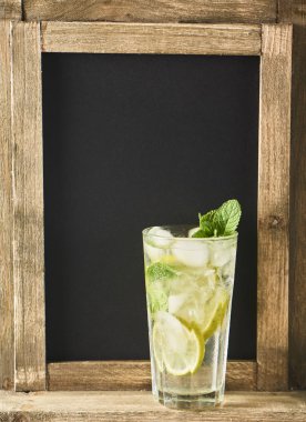 Mojito limes ve highball cam yazı tahtası arka planda nane kokteyli