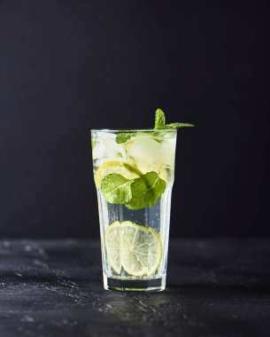 Mojito limes ve highball cam karanlık taş zemin üzerine nane kokteyli.