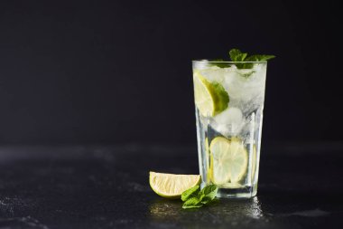 Mojito limes ve highball cam karanlık taş zemin üzerine nane kokteyli.