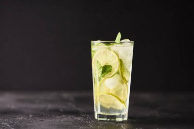 Mojito limes ve highball cam karanlık taş zemin üzerine nane kokteyli.