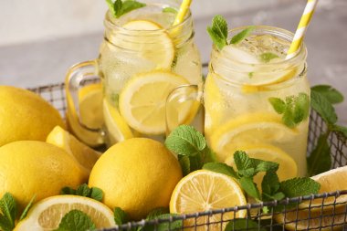 Beyaz beton zemin üzerine taze lezzetli limonata mason kavanozların içinde yakın çekim görünümü