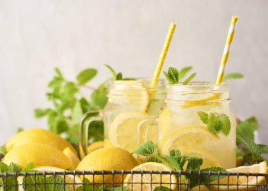 Beyaz beton zemin üzerine taze lezzetli limonata mason kavanozların içinde yakın çekim görünümü