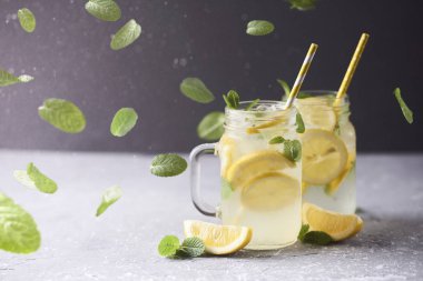 Taze lezzetli limonata koyu arka plan üzerinde mason kavanozların içinde. Düşen nane ve kar
