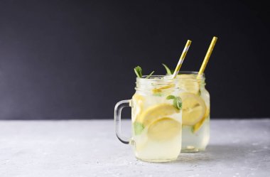 Koyu arka plan üzerinde mason cam kavanozlara taze lezzetli limonata.
