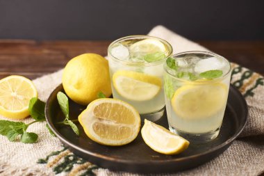 Koyu arka plan üzerinde bardaklarda taze lezzetli limonata.