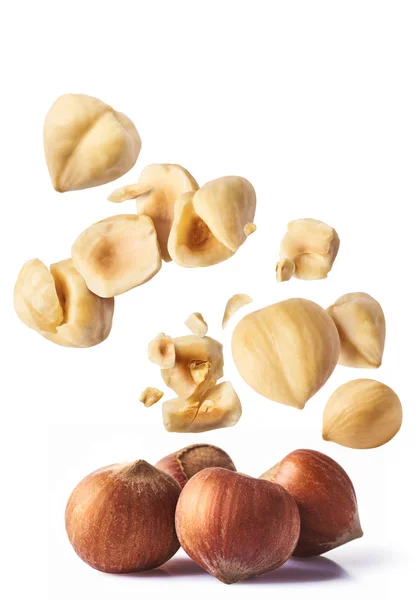 Hazelnuts crushed into pieces, frozen in the ai — Stock Photo, Image