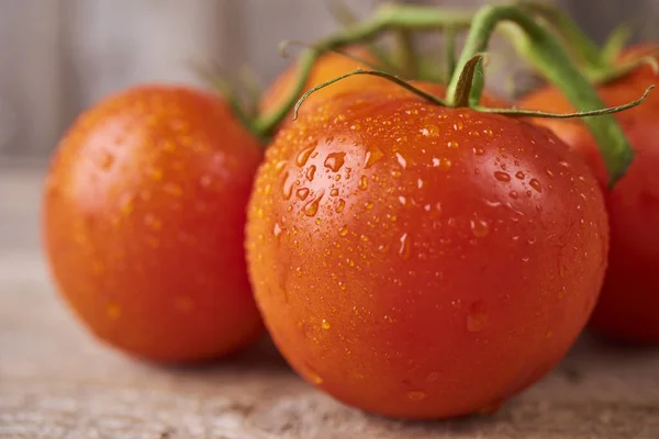 Fresh raw tomatoes over wooden background — Stok fotoğraf