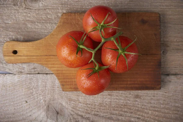 Verse rauwe tomaten op houten ondergrond — Stockfoto