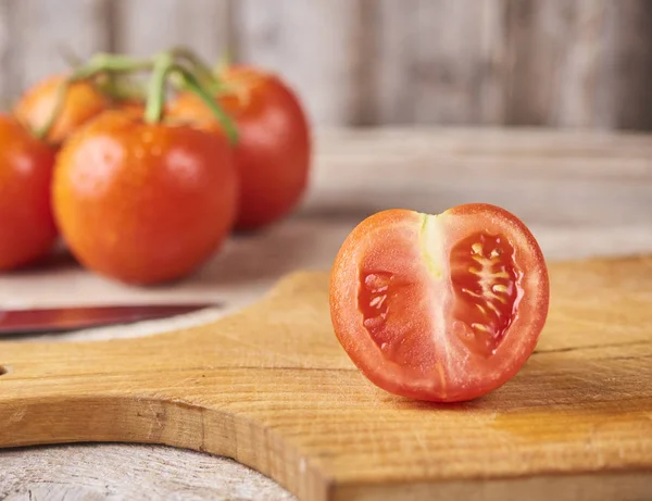 Frische rohe Tomaten vor hölzernem Hintergrund — Stockfoto