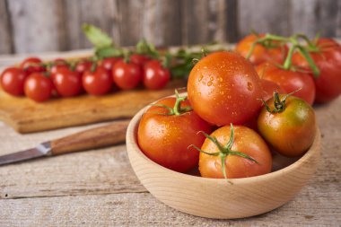 Fresh raw tomatoes over wooden background