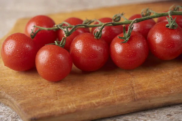 Frische rohe Tomaten vor hölzernem Hintergrund — Stockfoto