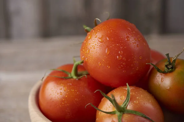 Frische rohe Tomaten vor hölzernem Hintergrund — Stockfoto