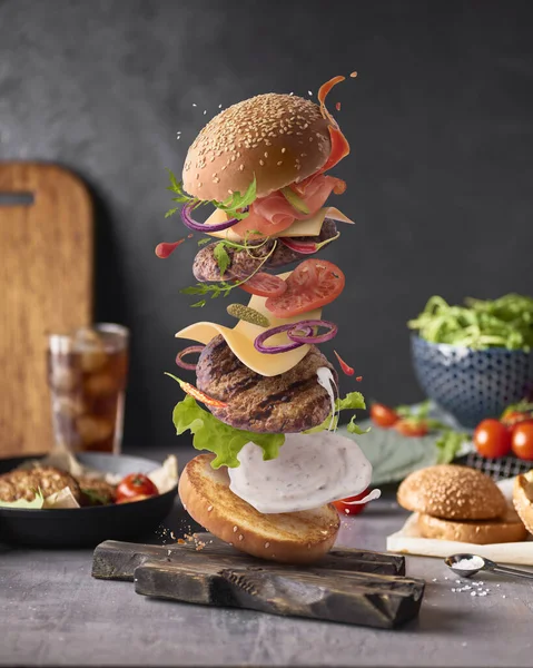 Delicious burger with flying ingredients