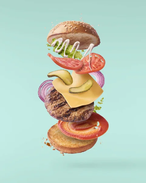 Delicious burger with flying ingredients isolated