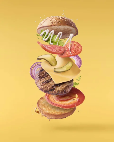 Delicious burger with flying ingredients isolated