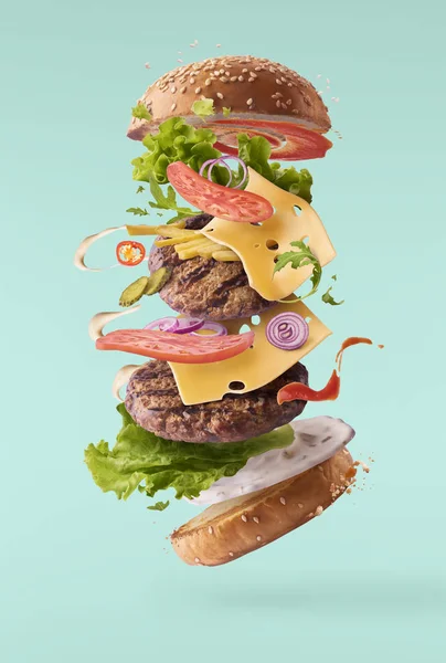 Delicious burger with flying ingredients — Stock Photo, Image