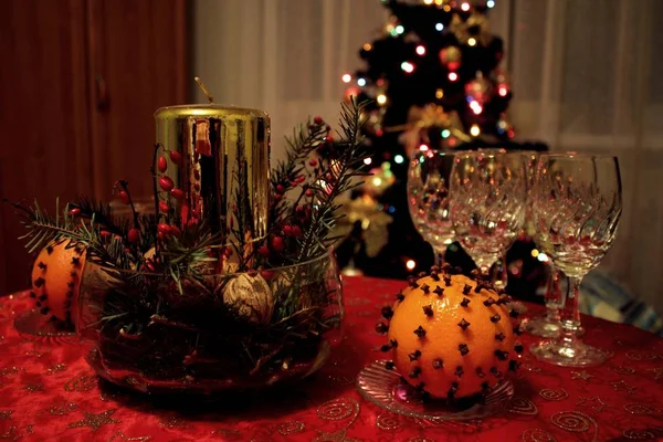 Süslenmiş mum, boş asma gözlük ve turuncu meyve Gillyflower ile closeup. Noel ağacı arka planda