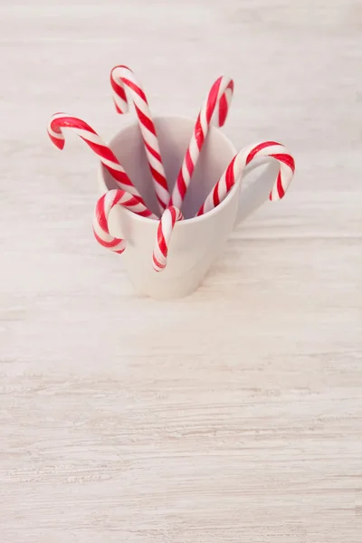 Bâtonnets de bonbons rouges et blancs de Noël dans une tasse — Photo