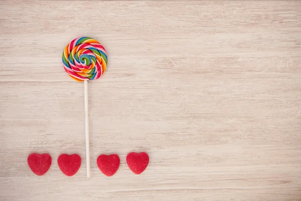 Paesaggio formato con un lecca-lecca e caramelle cuore — Foto Stock