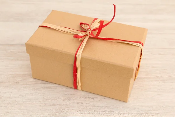 Güzel bir hediye ile kahverengi kağıt sarılı — Stok fotoğraf