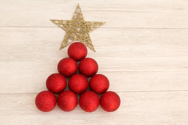 Christmas decorations arranged in tree shape — Stock Photo, Image