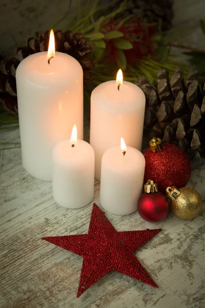 Свечи в рождественской обстановке с сезонными украшениями — стоковое фото