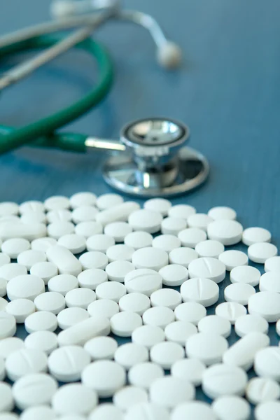Orvosi sztetoszkóppal, és fehér tabletta — Stock Fotó